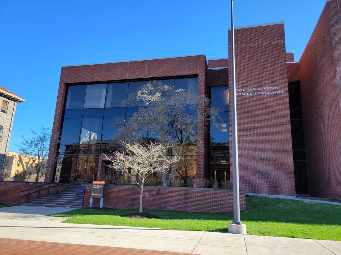 Exterior of a university geology laboratory building with a tree and clear blue sky, part of Syracuse University's campus where the five-pillar advising model was developed.
